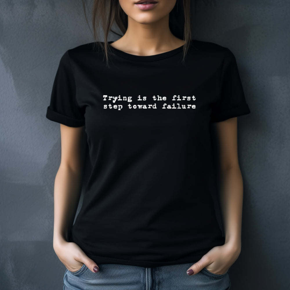 Black t-shirt with "Trying is the first step toward failure" in small white text on the chest in an old typewriter font